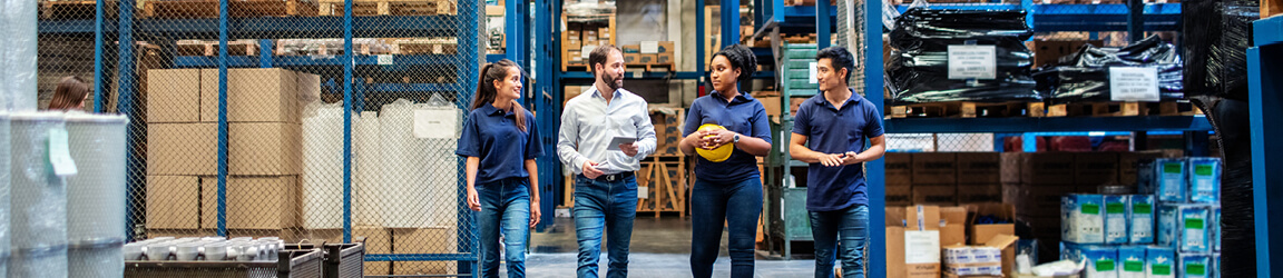 group of 4 talking and walking through warehouse