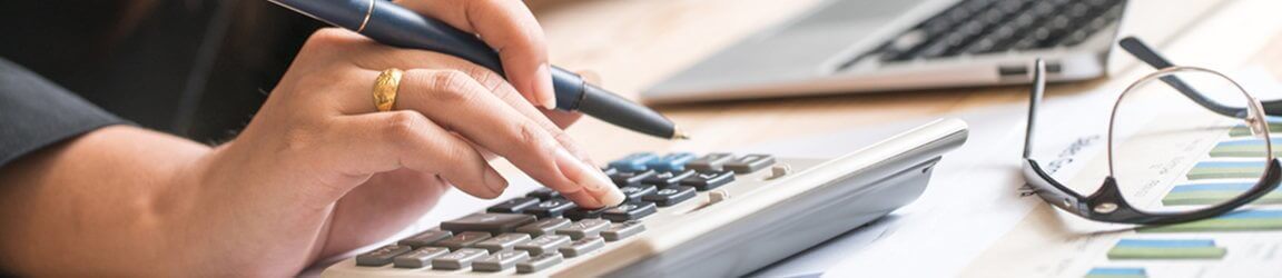 Female hands using calculator on an office desk