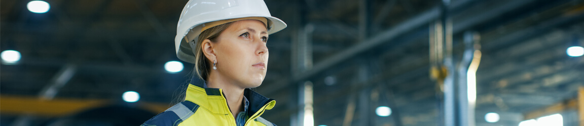 Female worker wearing hardhat in an industrial setting