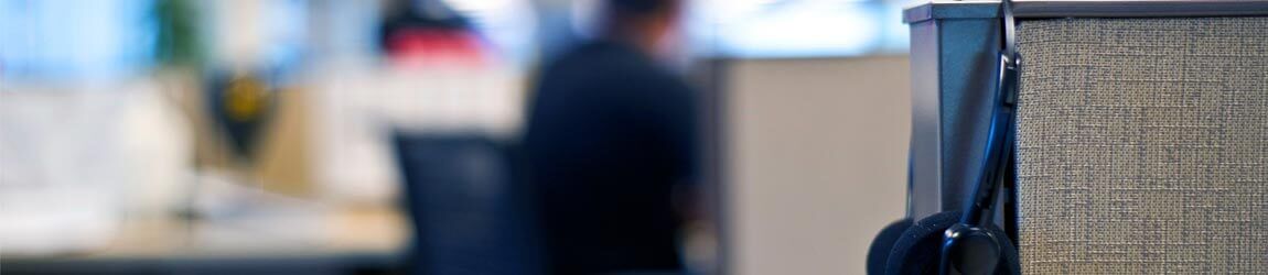 Headset handing on wall divider in an office