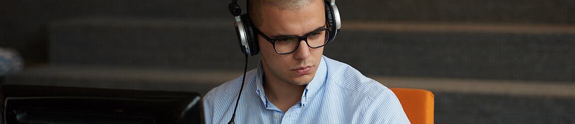 Man sitting in front of computer with headphones
