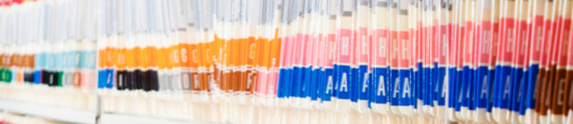 Medical records lined up in a file cabinet