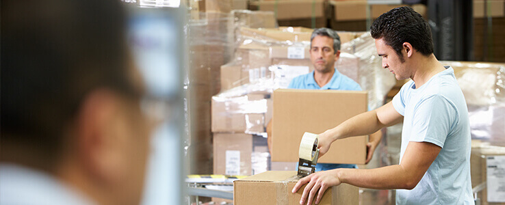 Three men packing boxes.