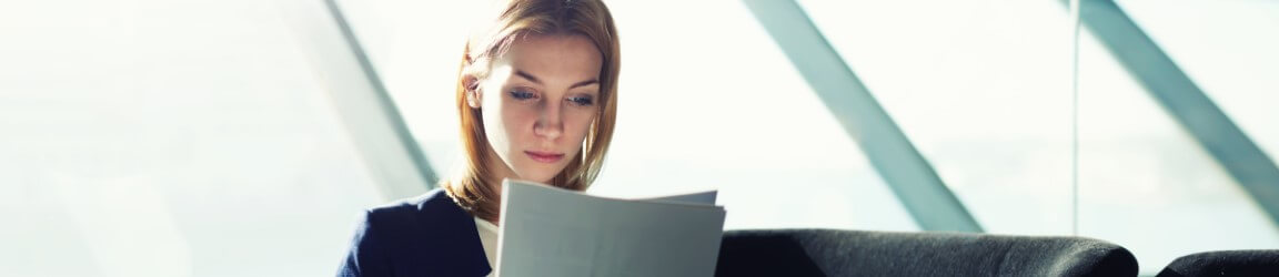 Young woman sitting reading a document | Aerotek.com