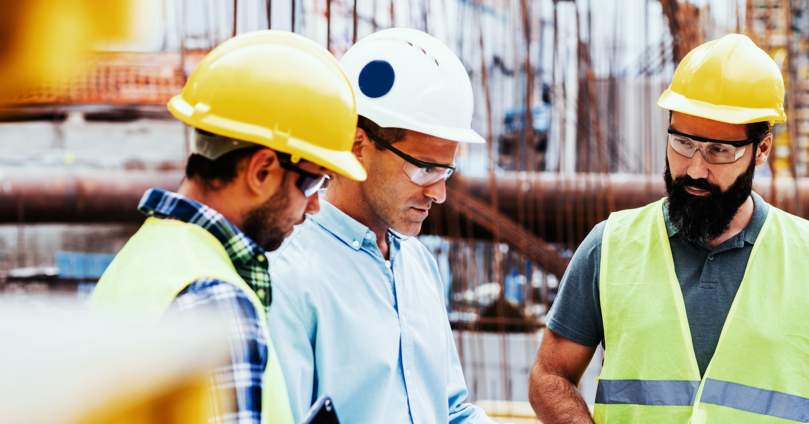 Project stakeholders examine construction drawings and discuss project execution at a data center job site.