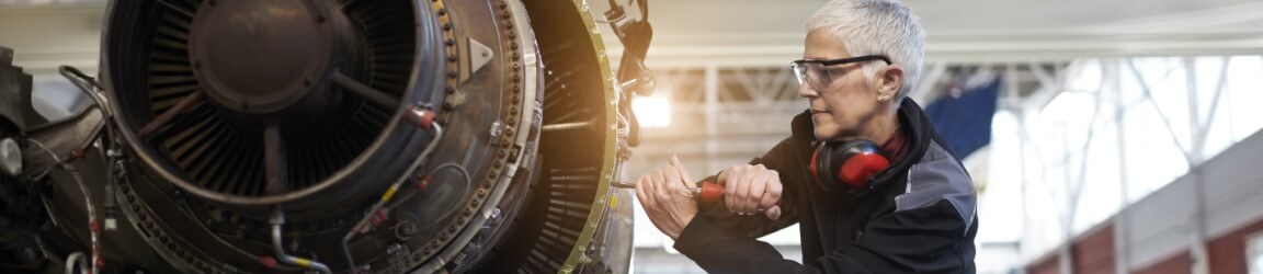 short-haired woman working on an aircraft