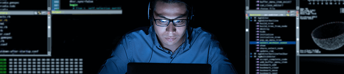 Software engineer working on laptop in the dark