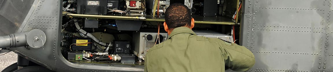 Military personnel repairing helicopter