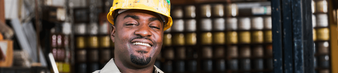 African American man wearing a hard had smiling at camera