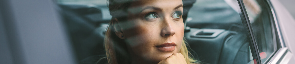 Woman sitting in a car looking out the window