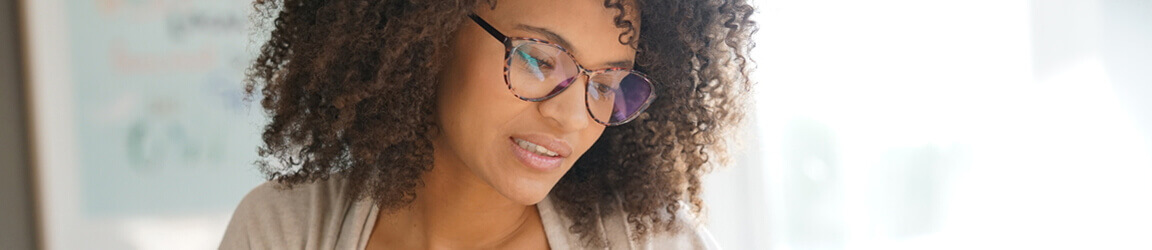 Woman wearing glasses working from home on a laptop