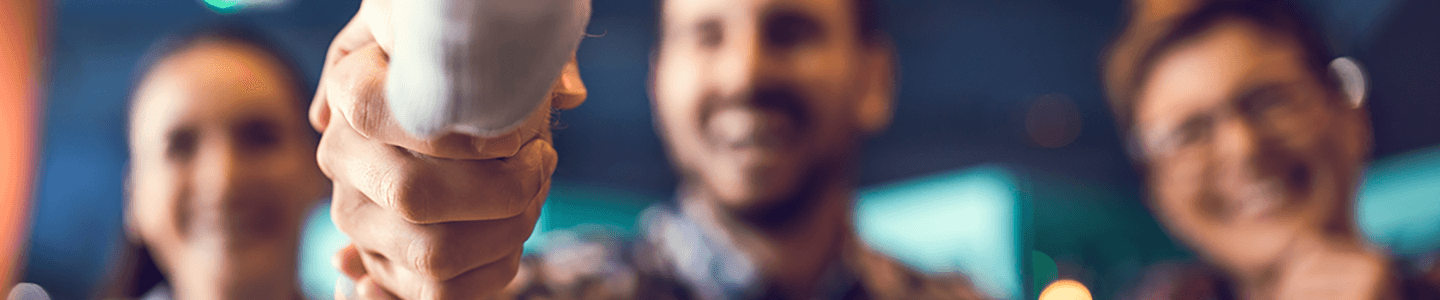 Closeup of shaking hands with blurry people
