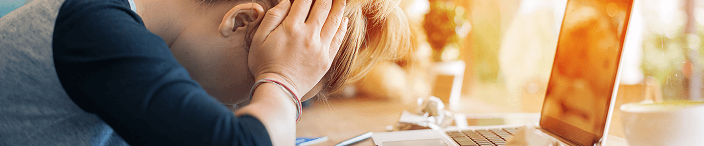 woman's head on desk near laptop
