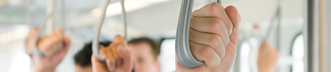 Commuters holding train handrail
