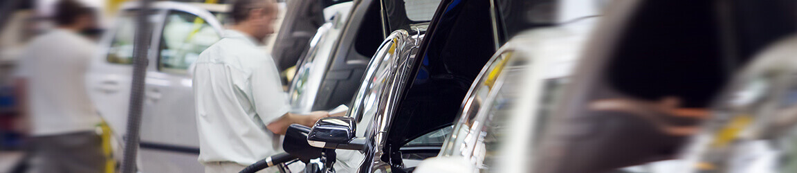 Engineer working on car in car plant