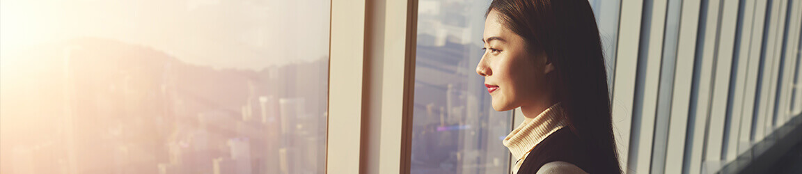 Woman overlooking city through a window
