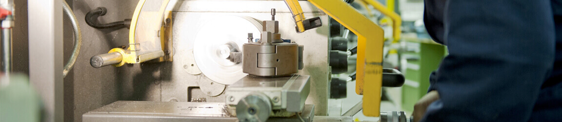 Worker in uniform operating cnc machine in a workshop